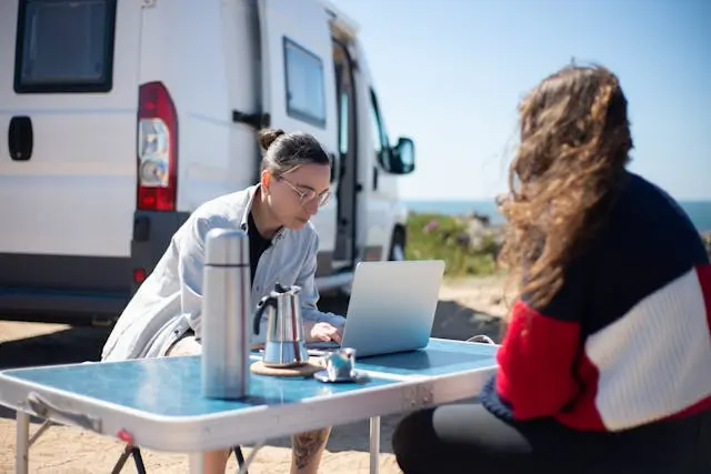dos mujeres frente a laptop al aire libre